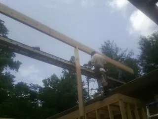Carpenter setting a ridge beam over a new addition frame — Ice Dam Removal by Roofing Brothers in Sarasota